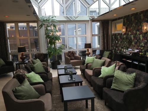 a living room with couches and tables and windows at Best Western Plus Edward Hotel in Lidköping