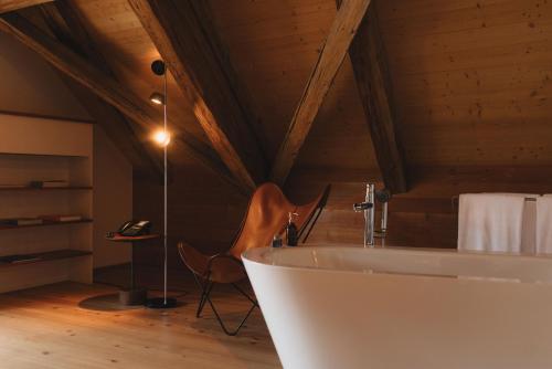 a bathroom with a white tub in a attic at Casa Caminada in Fürstenaubruck