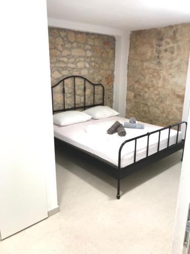 a bed in a room with a brick wall at HOLIDAY HOME m&n in Zaostrog
