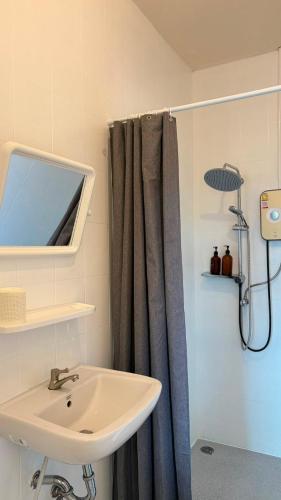 a bathroom with a sink and a shower curtain at Alura Boutique in Kata Beach