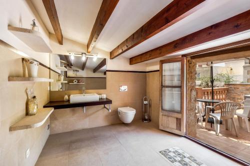 a bathroom with a sink and a toilet and a table at Can Vallori in Sencelles