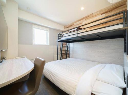 a bedroom with two bunk beds and a desk at Super Hotel Kushiro Kurogane in Kushiro