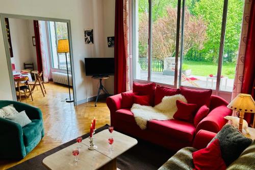 a living room with a red couch and a table at Magnificent duplex in a former Palace in Chamonix