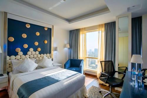 ein Schlafzimmer mit einem großen Bett und einer blauen Wand in der Unterkunft Grace21 Runway Hotel in Dhaka