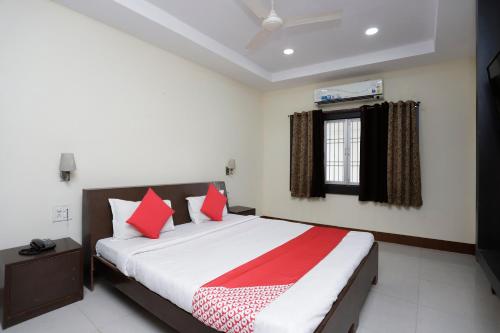 a bedroom with a large bed with red pillows at Hotel O Crown Hidden Residency in Satna