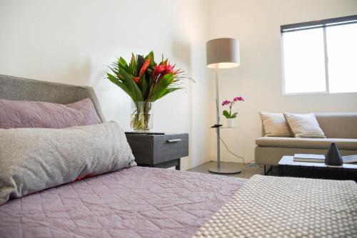 a bedroom with a bed with a vase of flowers at Hollywood Guesthouse in Los Angeles