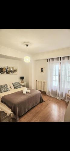 a bedroom with a large bed and a window at EL RINCON DE LUZ in Padrón