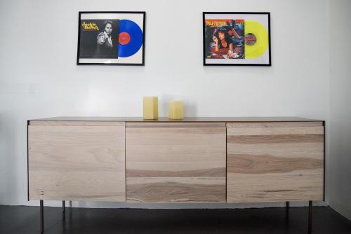 a wooden dresser against a white wall with two pictures at Hollywood Guesthouse in Los Angeles