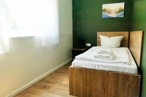 a bed with a wooden frame in a room at Gästehaus Gothensee in Heringsdorf