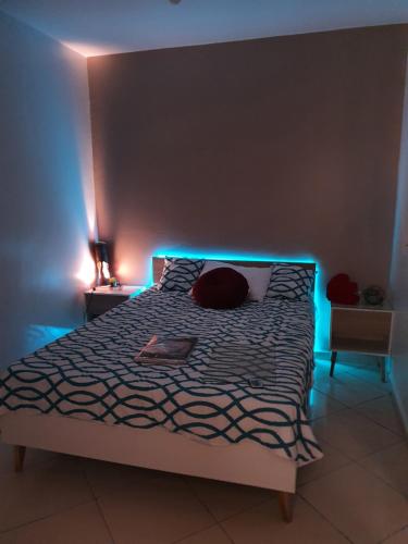 a bedroom with a bed with blue lights on it at la vue coucher de soleil in Hauara