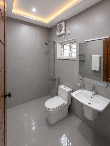a bathroom with a white toilet and a sink at Studio 13 in Islamabad