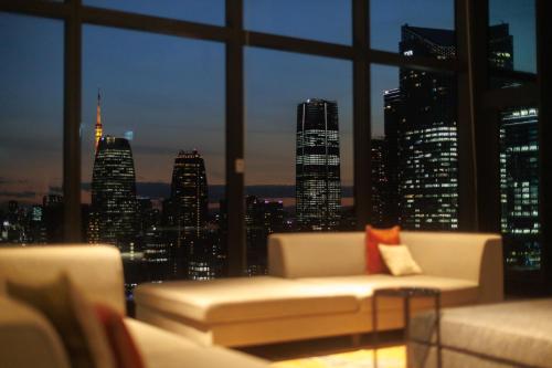 a living room with a view of a city skyline at THE BLOSSOM HIBIYA in Tokyo