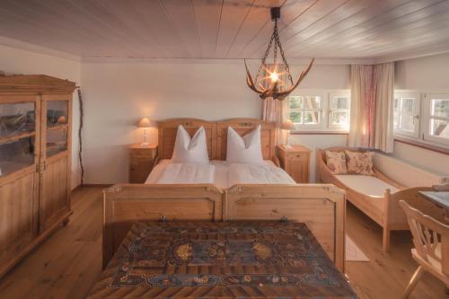 a bedroom with a bed and a couch and a chandelier at Ansitz Wartenfels in Thalgau