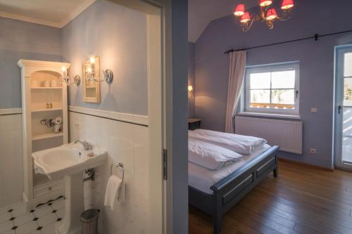 a bedroom with a bed and a sink and a window at Ansitz Wartenfels in Thalgau