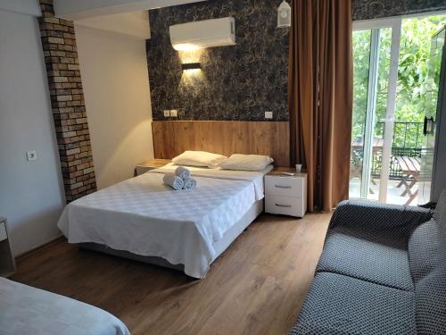 a hotel room with two beds and a chair at Garden Prizma Rooms&Aparts in Kemer