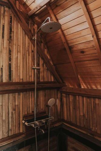 a room with a shower in a wooden wall at Kusfarm Bali by AHM in Selemadeg