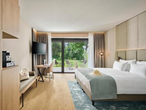a hotel room with a bed and a desk and a table at Jakobsberg Nature Resort - Hotel & Golf in Boppard