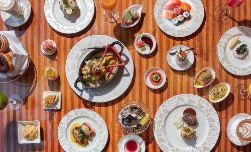 a wooden table with plates of food on it at The St. Regis Bali Resort in Nusa Dua