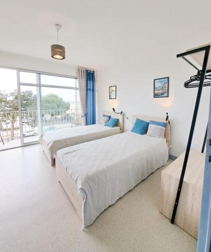 a bedroom with two beds and a large window at L'Océanic in Saint-Georges-de-Didonne