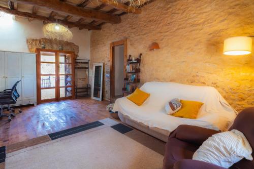 a bedroom with a bed and a stone wall at Can Vicent Corda in Sant Francesc Xavier