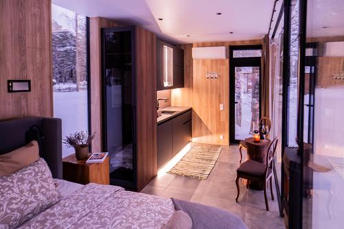 a bedroom with a bed and a table and a kitchen at Metsatiigi Resort in Kersalu