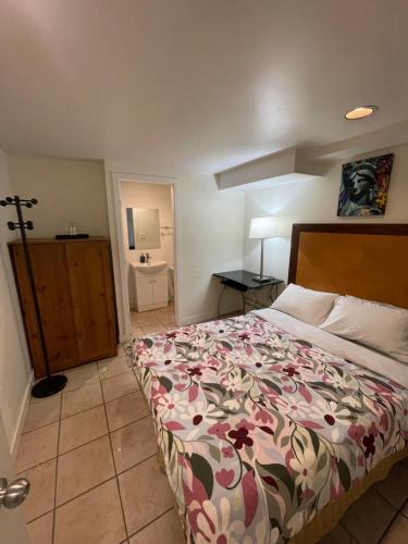 a bedroom with a bed with a floral bedspread at Manor guesthouse in Vancouver