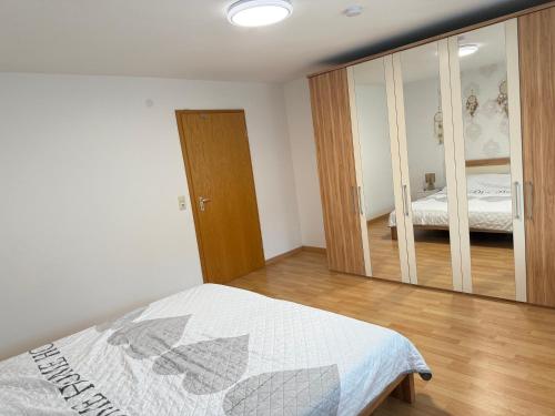 a bedroom with a bed and a large mirror at Wohnen am Rande des Schwarzwaldes in Eggingen