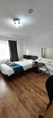 a bedroom with a bed and a desk in a room at Spacious Double Room with Shared Bathroom in London