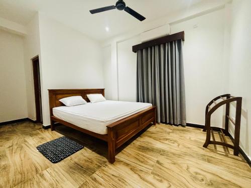 a bedroom with a bed and a ceiling fan at SB Guest in Trincomalee