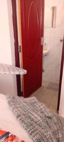 una stanza con una porta rossa e un bagno di The Amber Homes a Meru