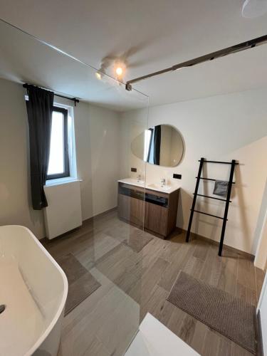 a bathroom with a tub and a sink and a mirror at Villa Médard in Bruges