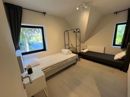a room with two beds and two windows at Villa Médard in Bruges
