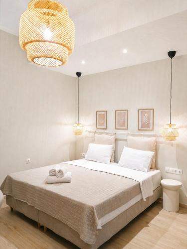 a bedroom with a large bed with a chandelier at Lithos in Palaiochora