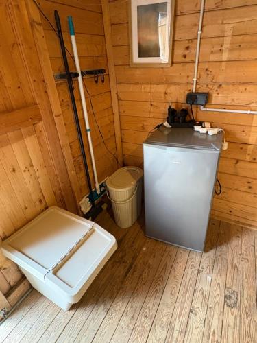 a bathroom with a toilet in a wooden cabin at la bulle d'Astrée in Le Tronchet