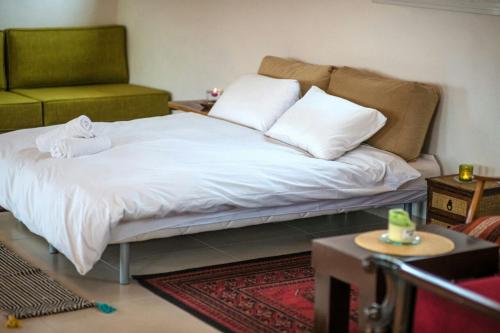 a bed with white sheets and pillows in a room at la noach in Metulla