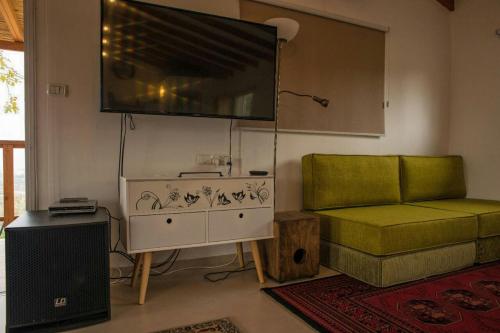 a living room with a couch and a large television at la noach in Metulla
