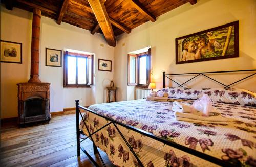 a bedroom with a large bed and a fireplace at Tenuta di Collestretto in Stazzano Nuovo