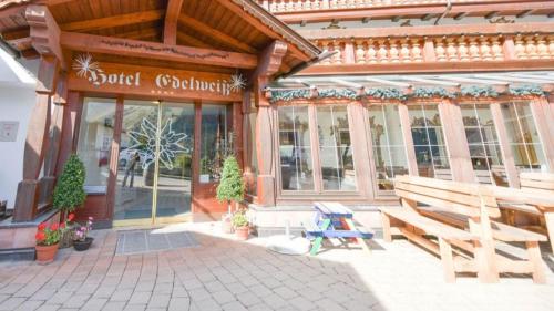 a building with a bench in front of a store at Hotel-Restaurant Edelweiẞ in Berwang