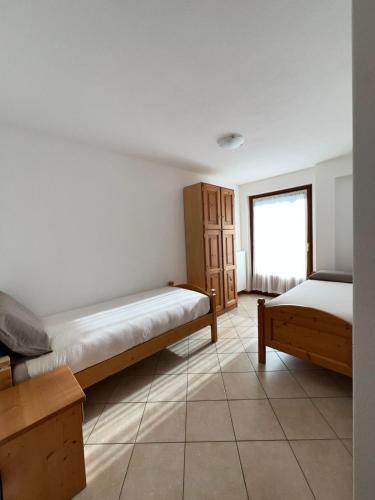 a room with two beds and a window at Alpine Living Apartments in Bormio