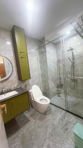 a bathroom with a toilet and a shower and a sink at Căn hộ Na Uy in Nha Trang