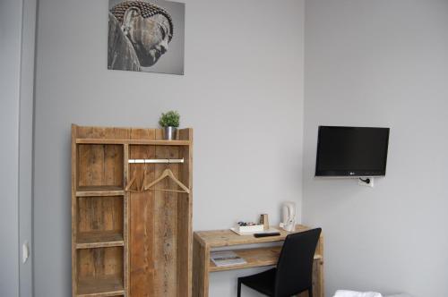 a room with a desk and a tv on a wall at Hotel de Prince in Nijmegen