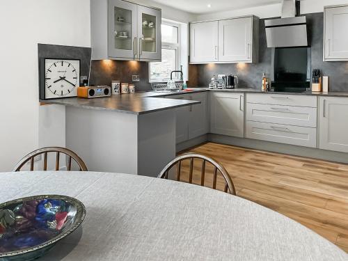 a kitchen with a table and a clock on the wall at The Anchorage in Collieston