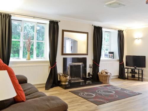 a living room with a couch and a fireplace at Burnbeag - Svve in Balloch