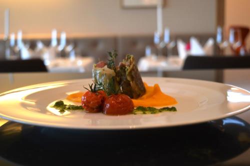 a white plate with food on a table at Hotel TheGreen in Cologne