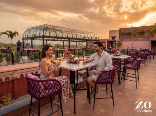 a man and a woman sitting at a table on a patio at Zo Selections Jaipur by Zostel in Jaipur