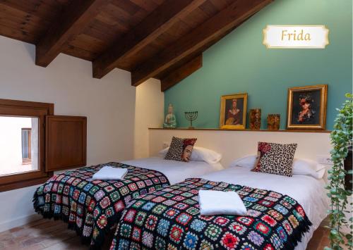 two beds sitting next to each other in a room at Cal Cabré del Priorat - Alojamiento y Bienestar in Pradell