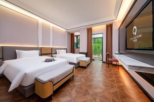 a hotel room with two beds and a flat screen tv at Q.pavilion hotel in Baihe