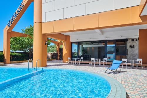 a swimming pool in front of a hotel at Boyokaku in Amakusa