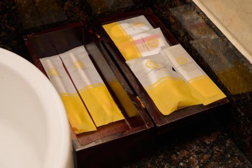 a wooden drawer filled with yellow and white products at Phnom Penh Katari Hotel in Phnom Penh