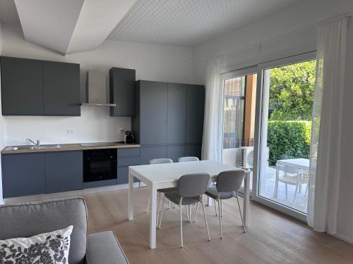 a kitchen and dining room with a white table and chairs at Appartamento Stella - 15' walk to Abano Terme centre in Abano Terme